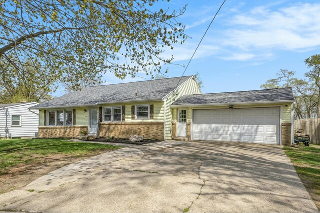 view of front facade featuring fence, brick siding, a garage, a front yard, and concrete driveway