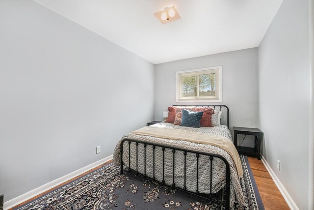 bedroom featuring baseboards and wood finished floors