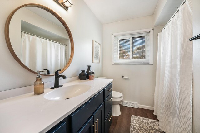 full bathroom with visible vents, wood finished floors, vanity, baseboards, and toilet