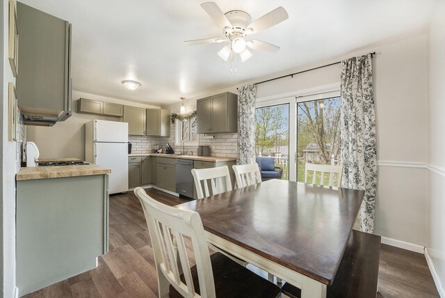 dining room with dark wood-style flooring, ceiling fan, and baseboards