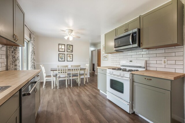 kitchen with dark wood-style flooring, butcher block counters, a ceiling fan, backsplash, and stainless steel appliances