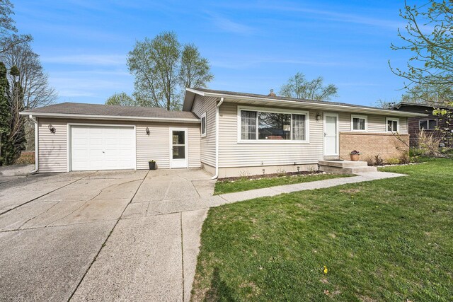 ranch-style home with an attached garage, concrete driveway, and a front lawn