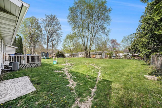 view of yard with a fenced backyard, a playground, a wooden deck, and cooling unit