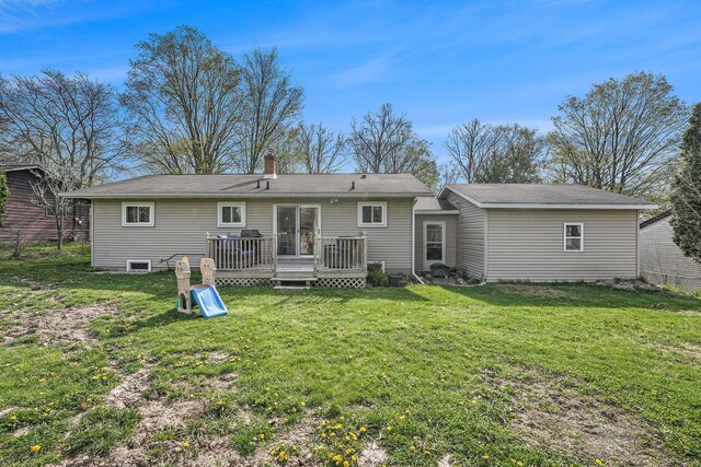 back of house featuring fence, a wooden deck, a chimney, and a yard