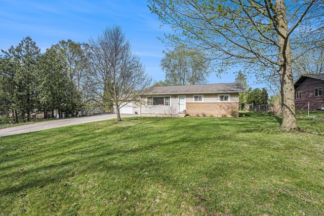 ranch-style house featuring fence, driveway, a chimney, and a front lawn