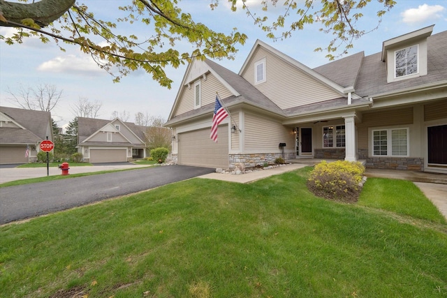 view of front of home featuring stone siding, a front lawn, a garage, driveway, and a shingled roof