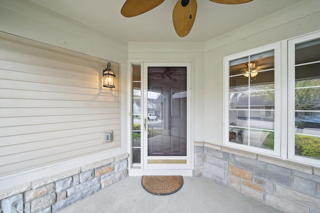 entrance to property featuring stone siding and a ceiling fan