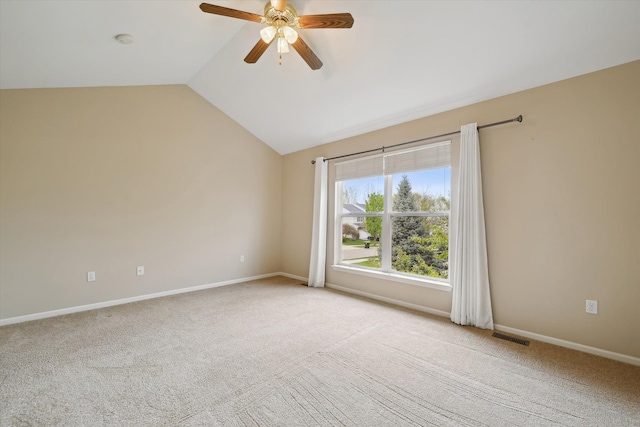 spare room featuring lofted ceiling, light colored carpet, a ceiling fan, a smoke detector, and baseboards