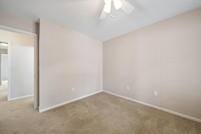 carpeted empty room with ceiling fan and baseboards