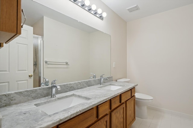 bathroom with a stall shower, toilet, tile patterned flooring, double vanity, and baseboards
