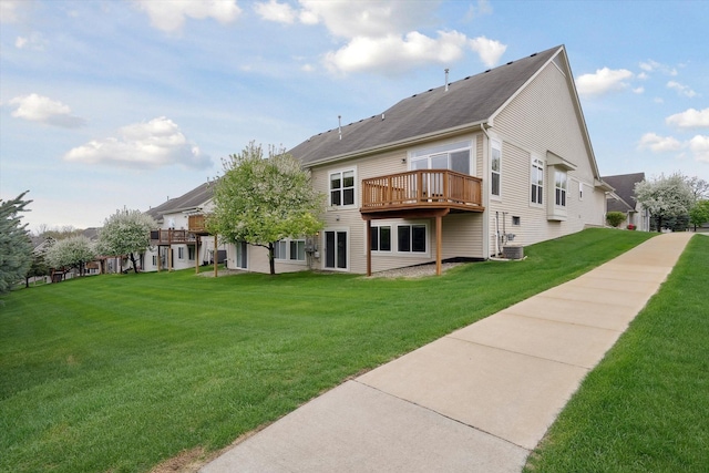 back of property with a lawn, a deck, and cooling unit
