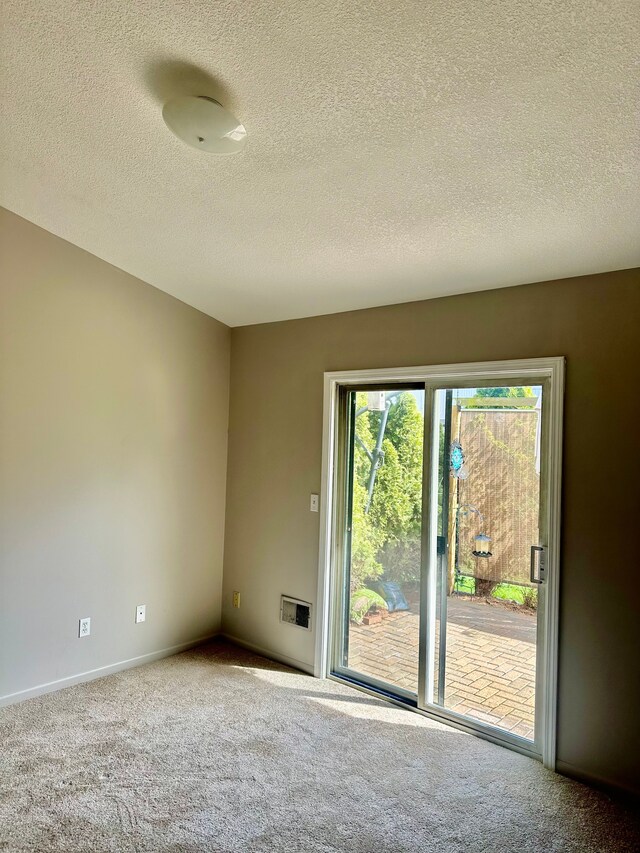 unfurnished room with baseboards, a textured ceiling, and carpet