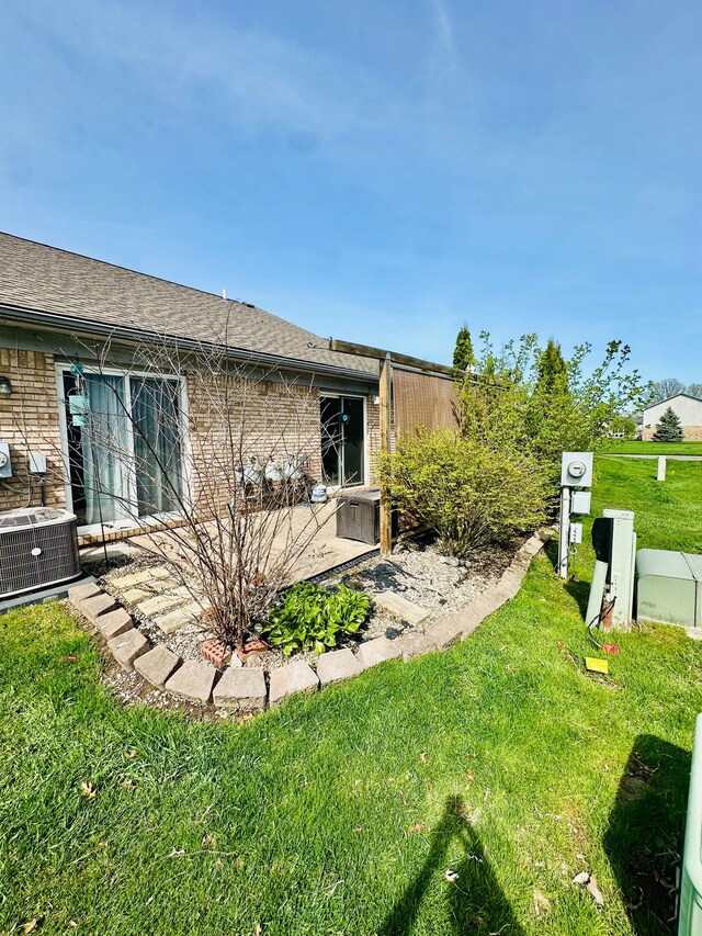 view of yard with central air condition unit and a patio