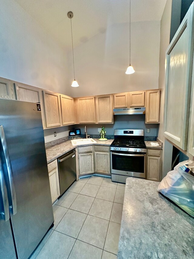 kitchen with light tile patterned flooring, light brown cabinets, under cabinet range hood, a sink, and stainless steel appliances