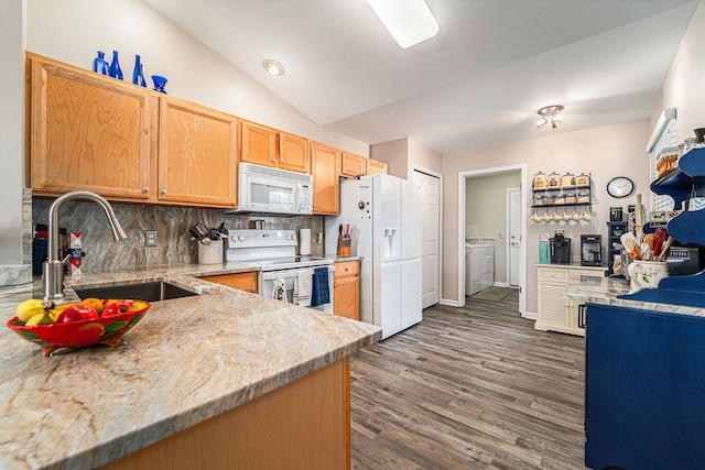 kitchen with a sink, white appliances, separate washer and dryer, backsplash, and dark wood-style floors