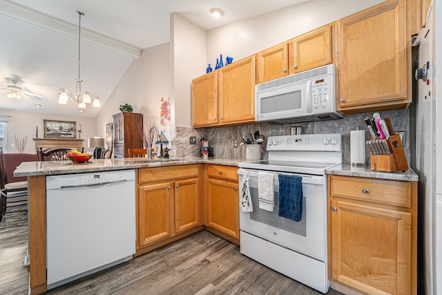 kitchen featuring a sink, a peninsula, white appliances, light wood finished floors, and vaulted ceiling with beams