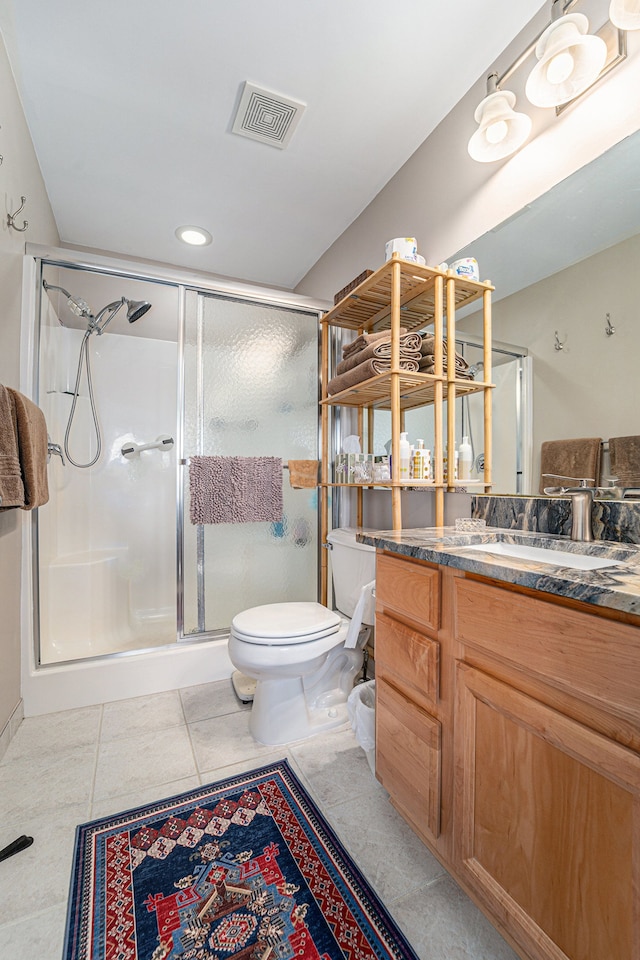 bathroom featuring vanity, visible vents, toilet, and a shower stall