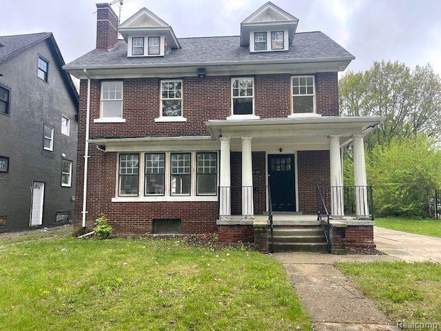 1485 Longfellow St, Detroit, MI 48206 - view of front of property featuring brick siding, a front yard, covered porch, and a chimney