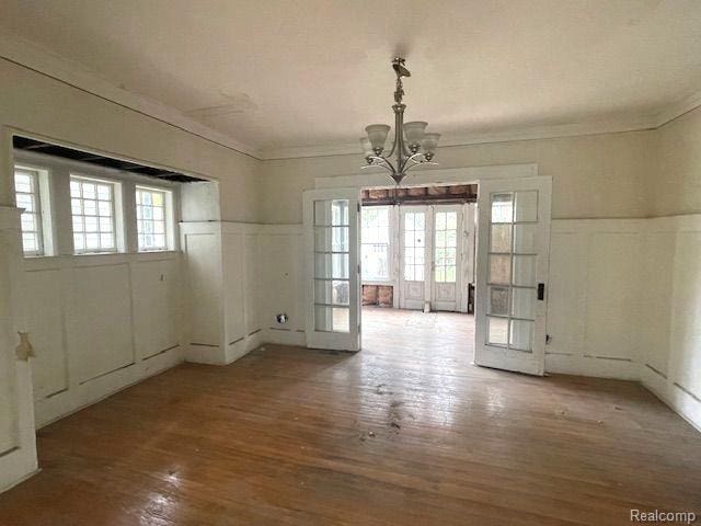 1485 Longfellow St, Detroit, MI 48206 - unfurnished dining area with french doors, a chandelier, a decorative wall, ornamental molding, and wood finished floors