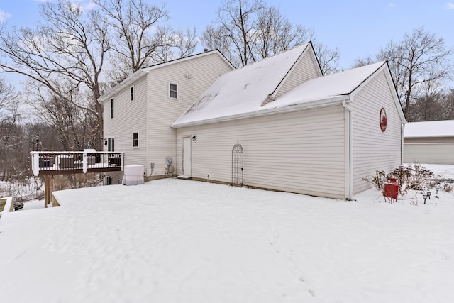 snow covered house featuring a deck