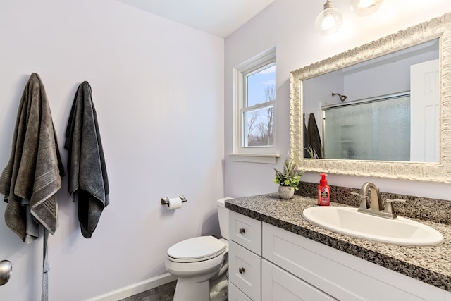 full bath featuring toilet, baseboards, a shower stall, and vanity