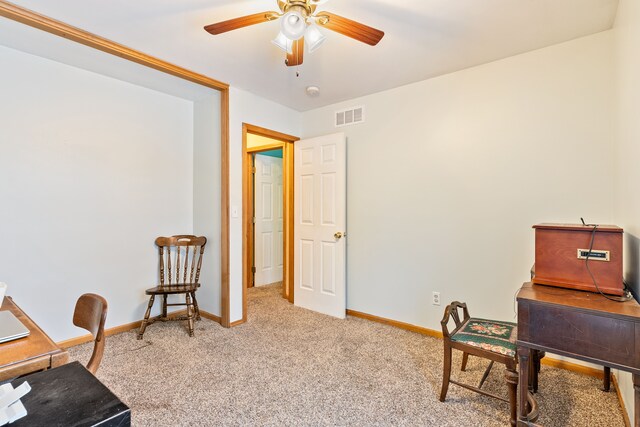 office space with carpet floors, ceiling fan, baseboards, and visible vents