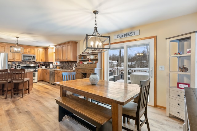 2008 Laurel Oak Dr, Howell, MI 48855 - dining area featuring a chandelier and light wood-style flooring