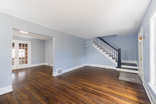 unfurnished living room with french doors, baseboards, wood finished floors, visible vents, and stairway