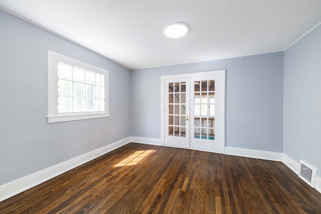 empty room featuring baseboards, french doors, wood finished floors, and visible vents