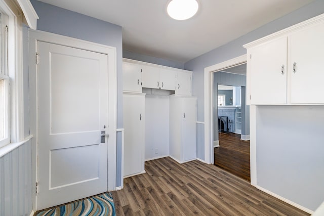 mudroom with a brick fireplace, baseboards, and dark wood-style floors