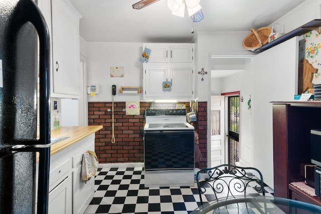 11718 Wayburn St, Detroit, MI 48224 - kitchen with freestanding refrigerator, tile patterned floors, white cabinetry, light countertops, and brick wall