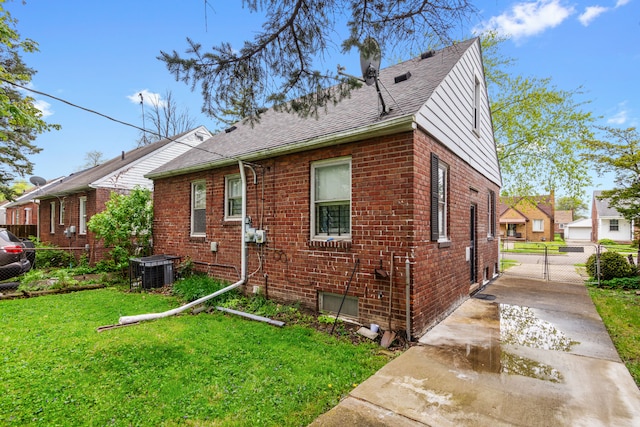 11718 Wayburn St, Detroit, MI 48224 - view of home's exterior featuring brick siding, roof with shingles, central AC unit, and a gate