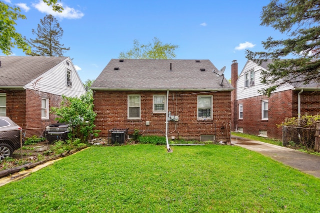 11718 Wayburn St, Detroit, MI 48224 - back of property featuring brick siding, roof with shingles, and cooling unit