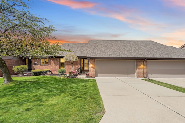 view of front of property with a lawn, a garage, brick siding, concrete driveway, and a shingled roof