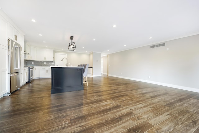 kitchen with a kitchen island with sink, visible vents, crown molding, appliances with stainless steel finishes, and a sink