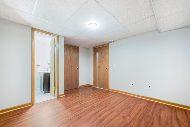 unfurnished room featuring a paneled ceiling, baseboards, and wood finished floors