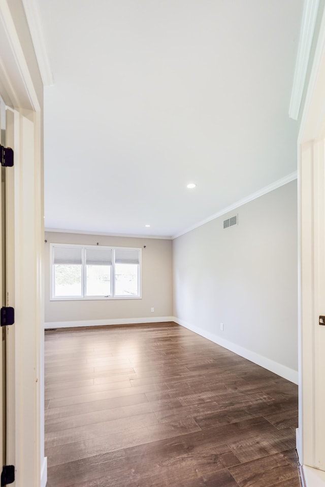 spare room with crown molding, baseboards, visible vents, and dark wood-style floors