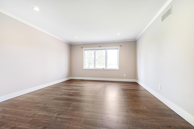 spare room featuring crown molding, dark wood-style flooring, baseboards, and visible vents