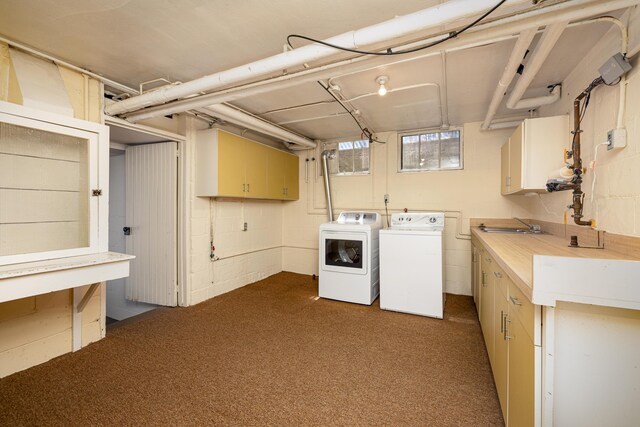 clothes washing area with cabinet space, separate washer and dryer, a sink, and dark colored carpet