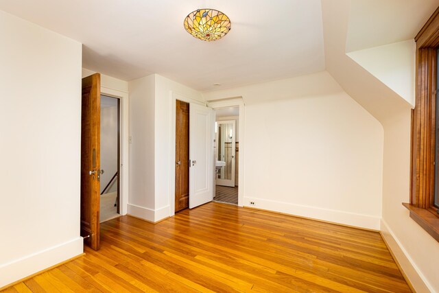 additional living space featuring light wood-style floors and baseboards