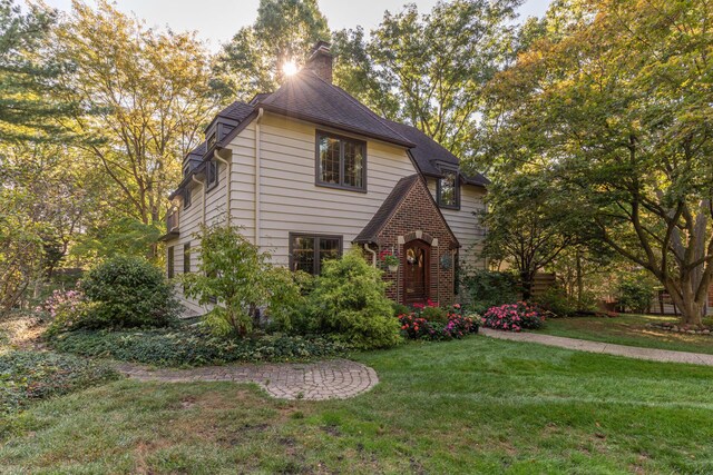 tudor house with a front yard and a chimney