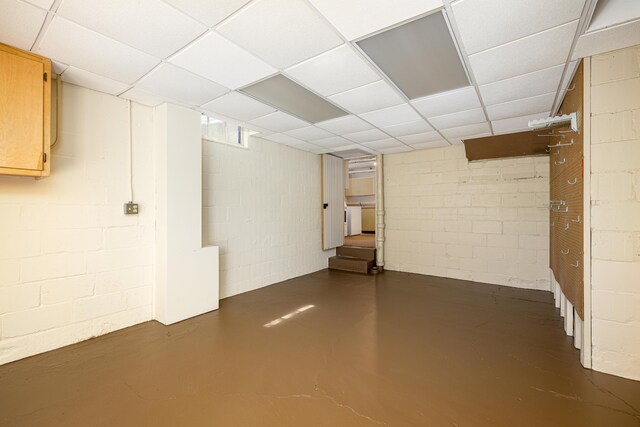 finished below grade area featuring stairs and concrete block wall