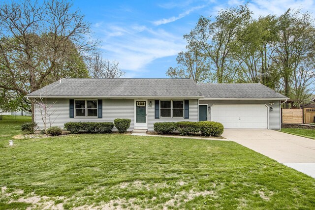 ranch-style home with fence, a shingled roof, an attached garage, a front lawn, and driveway