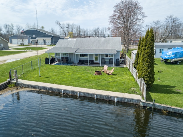 rear view of property with a water view, a patio area, a detached garage, and roof with shingles