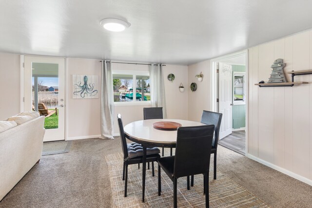 carpeted dining space with baseboards