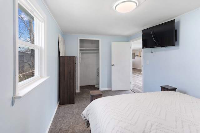 carpeted bedroom featuring a closet, baseboards, and crown molding