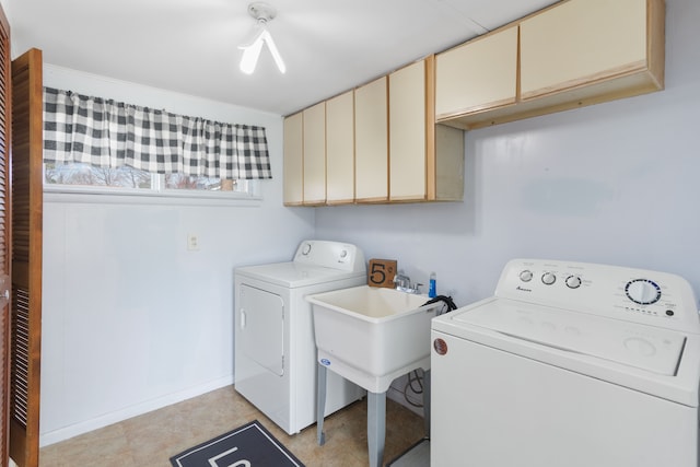 washroom with cabinet space, washer and dryer, and baseboards
