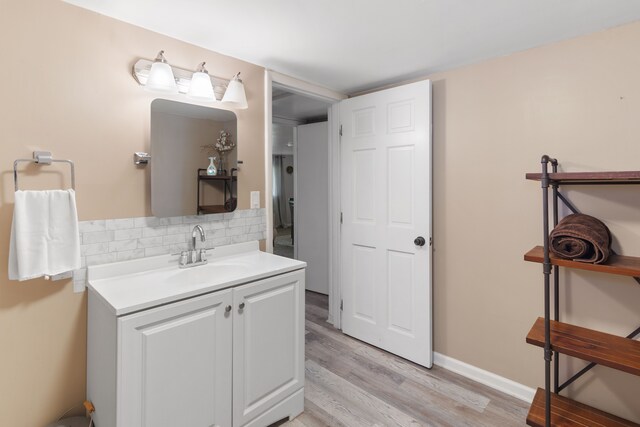 bathroom with wood finished floors, tasteful backsplash, and vanity