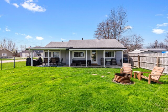 back of property with an outdoor fire pit, a patio area, and a shingled roof