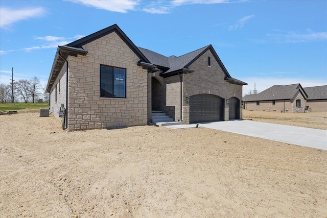 720 Marlayna Dr, Oxford, MI 48371 - french provincial home featuring concrete driveway, an attached garage, central AC unit, and stone siding